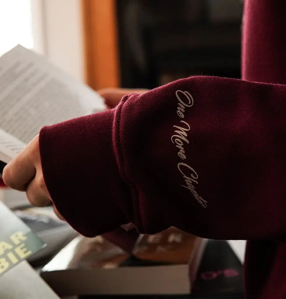 Close-up of the burgundy sweatshirt sleeve with 'One More Chance' script text near the wrist area.